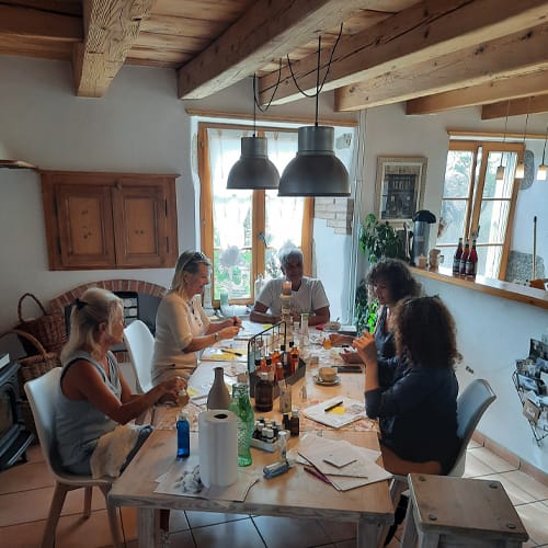 5 personnes assises à une table et faisant une activité créative.