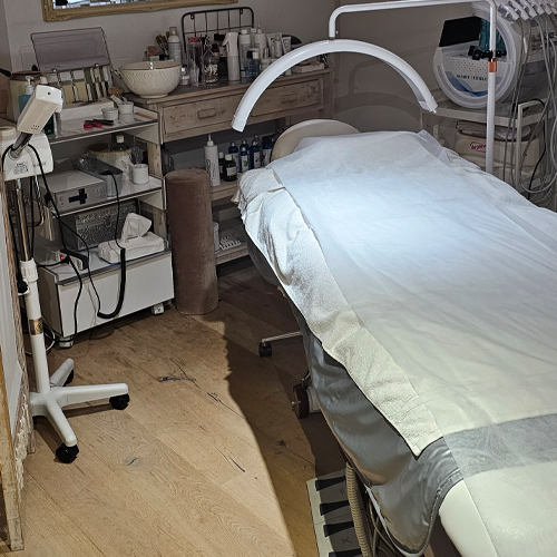 Vue d'ensemble d'une table de massage avec des produits esthétiques en arrière-plan.