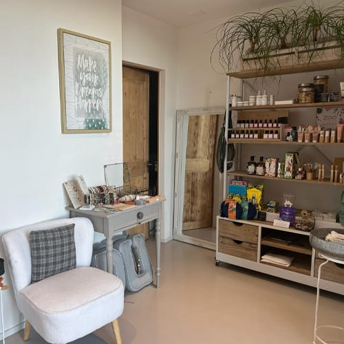 Coins d'une pièce : à droite, une étagère ; à gauche, un fauteuil.