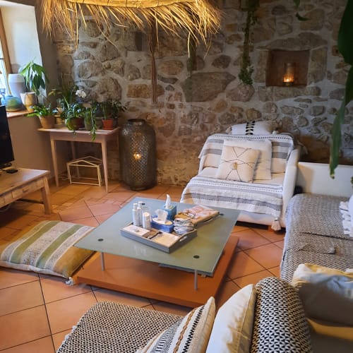 Beau salon avec un canapé et une table basse avec des produits cosmétiques posés dessus.