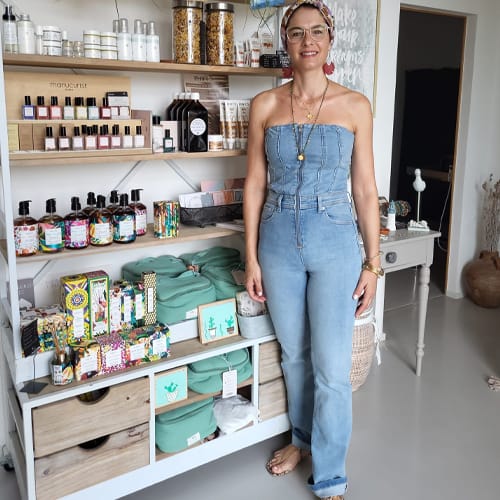 Marie Mattei debout devant une étagère remplie de cosmétiques.